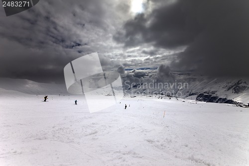 Image of Ski slope, skiers and sky with storm clouds