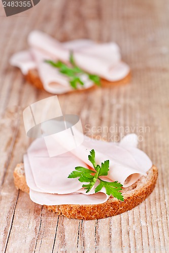 Image of bread with sliced ham and parsley