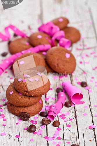 Image of fresh chocolate cookies, coffee beans, pink ribbons and confetti