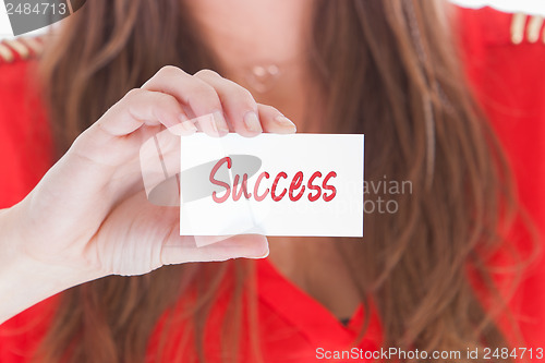 Image of Woman in red showing a business card