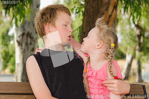 Image of Two friends boy and girl hugging in park