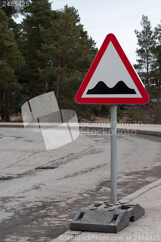 Image of Sign and potholes on the road