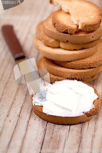 Image of snack crackers with cream cheese and knife 