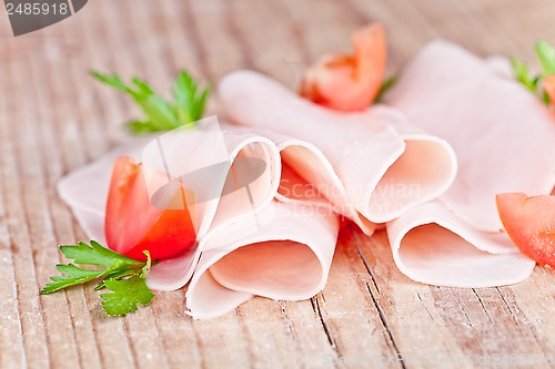 Image of slices of ham with parsley and tomato 