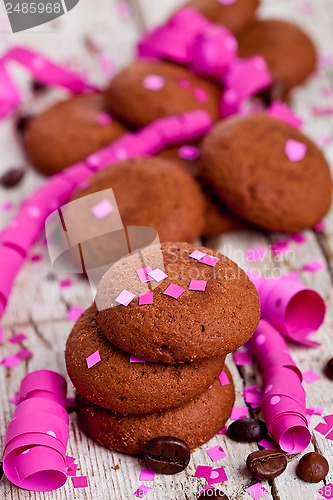 Image of fresh chocolate cookies, coffee beans, pink ribbons and confetti