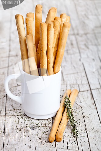 Image of cup with bread sticks grissini and rosemary