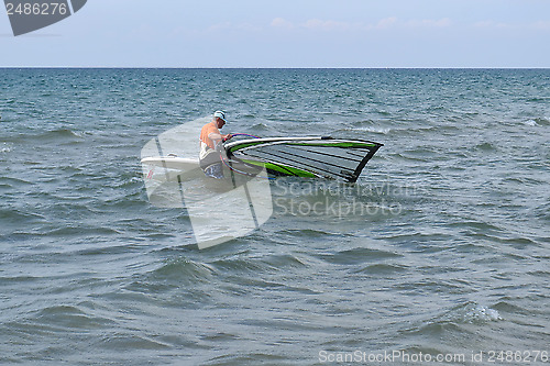 Image of The man is engaged in windsurfing in the sea