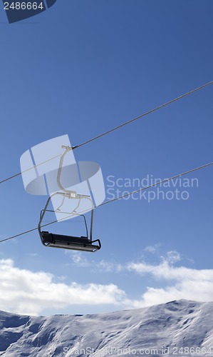 Image of Chair lift and snowy mountains at nice day