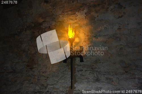 Image of torch on the wall of an old castle