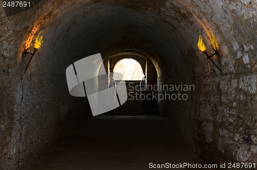 Image of catacombs of the old castle illuminated burning torches