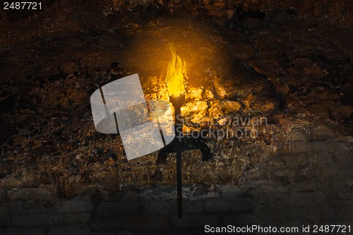 Image of torch on the wall of an old castle