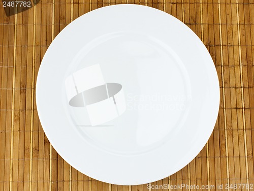 Image of white plate on a bamboo napkin