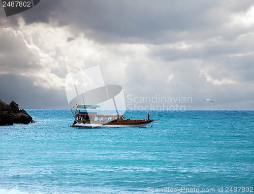 Image of boat in the sea and stormy sky
