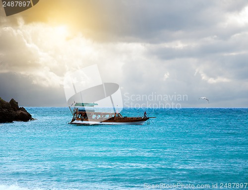 Image of boat in the sea and stormy sky