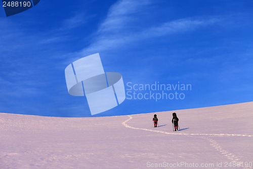 Image of Two hikers on sunrise snowy plateau