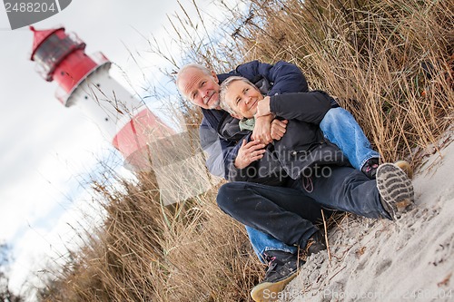 Image of happy mature couple relaxing baltic sea dunes 