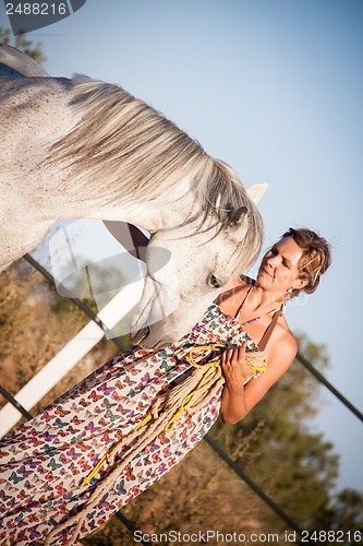 Image of young woman walking a road with horse