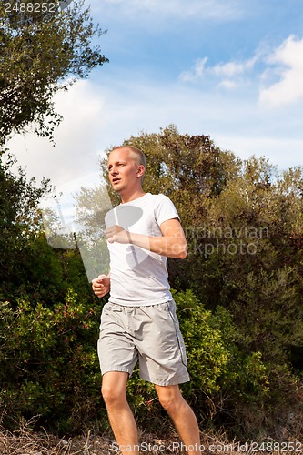 Image of athletic man runner jogging in nature outdoor