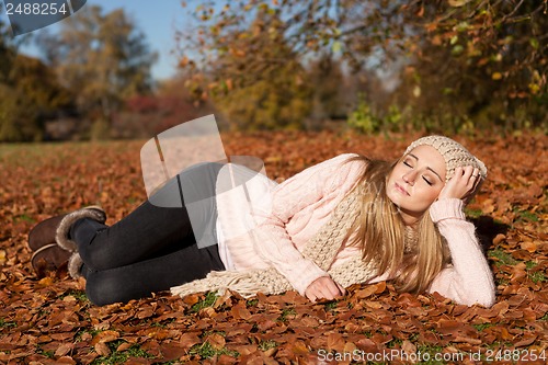 Image of young smiling woman with hat and scarf outdoor in autumn