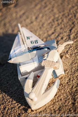 Image of sailing boat and seashell in sand decoration closeup