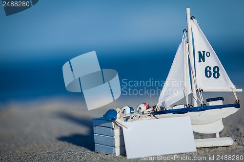 Image of sailing boat and seashell in sand decoration closeup