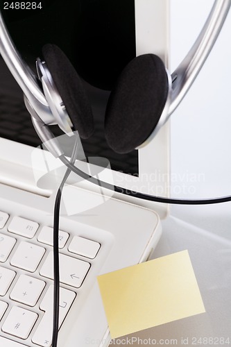 Image of headset keyboard notebook laptop in office on table desk