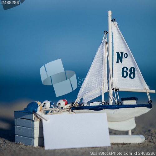 Image of sailing boat and seashell in sand decoration closeup