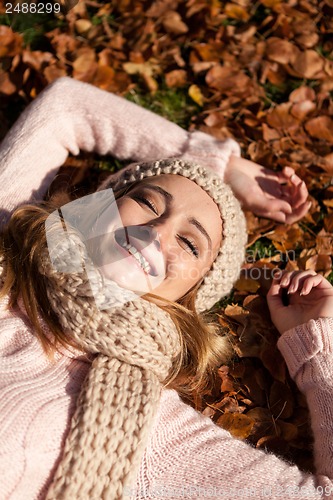 Image of young smiling woman with hat and scarf outdoor in autumn