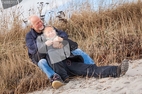 Image of happy mature couple relaxing baltic sea dunes 