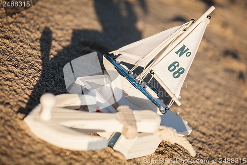 Image of sailing boat and seashell in sand decoration closeup