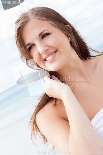 Image of smiling young brunette woman in summer on the beach 