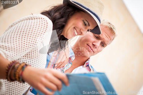 Image of young attractive tourist couple with city map in summer