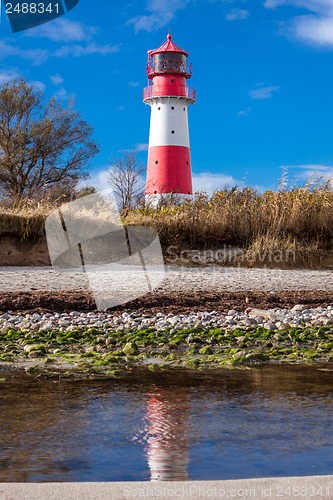 Image of landscape baltic sea dunes lighthouse in red and white 