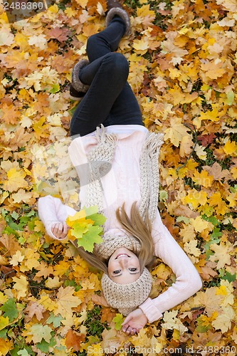 Image of attractive young woman relaxing in atumn park outdoor