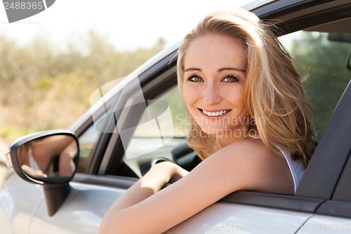 Image of young attractive happy woman sitting in car summertime