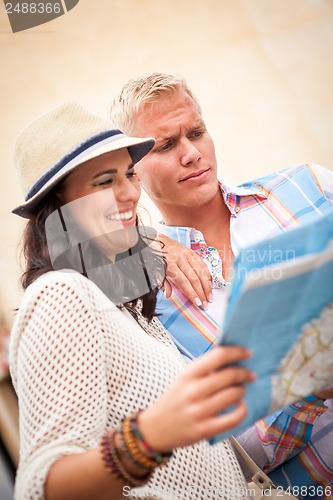 Image of young attractive tourist couple with city map in summer