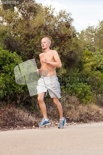 Image of athletic man runner jogging in nature outdoor