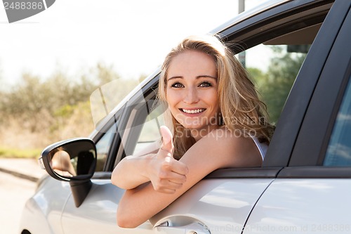 Image of young attractive happy woman sitting in car summertime