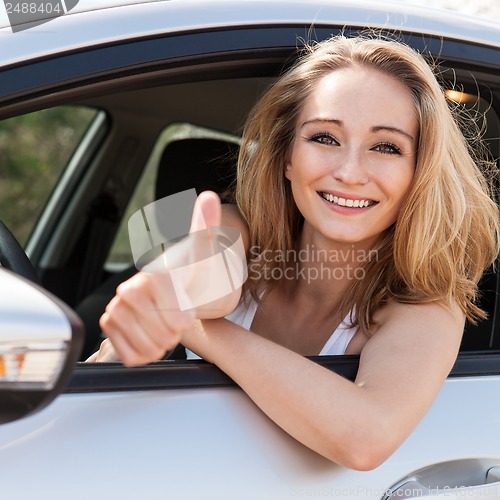 Image of young attractive happy woman sitting in car summertime