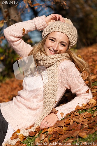 Image of young smiling woman with hat and scarf outdoor in autumn