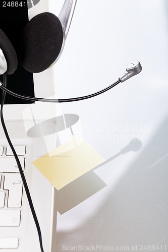 Image of headset keyboard notebook laptop in office on table desk