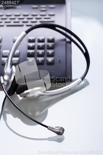 Image of office desk with telephone and headset objects 