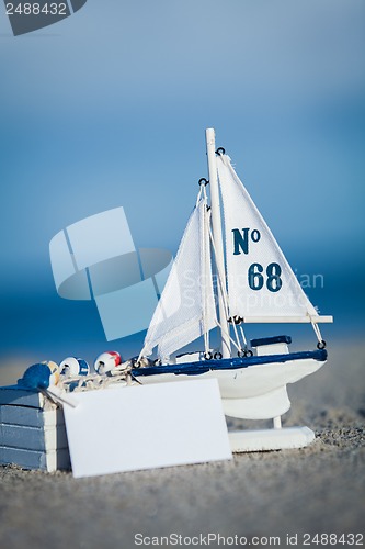 Image of sailing boat and seashell in sand decoration closeup