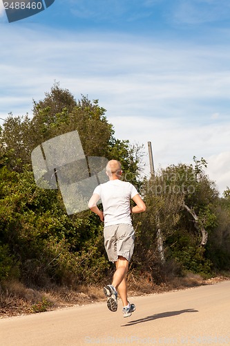 Image of athletic man runner jogging in nature outdoor