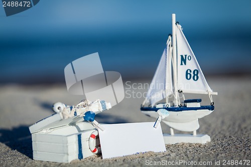 Image of sailing boat and seashell in sand decoration closeup