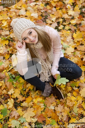 Image of attractive young woman relaxing in atumn park outdoor