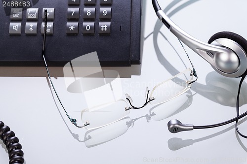 Image of working place office desk table headset glasses telephone