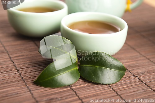 Image of A cup of green tea with freh leaves