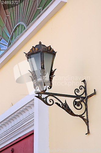 Image of Old lamp with stained glass window on wall