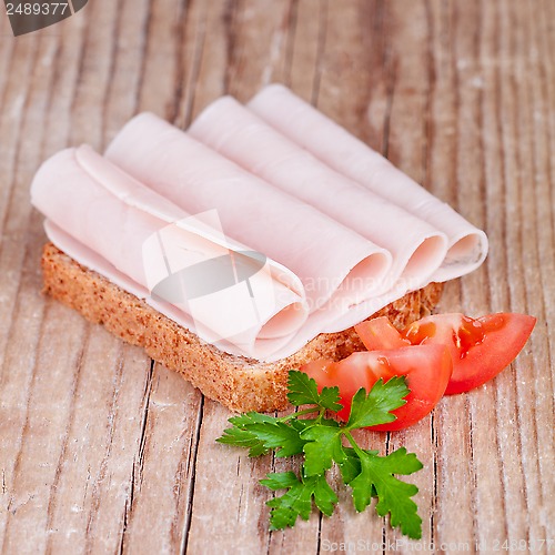 Image of bread with sliced ham, fresh tomatoes and parsley